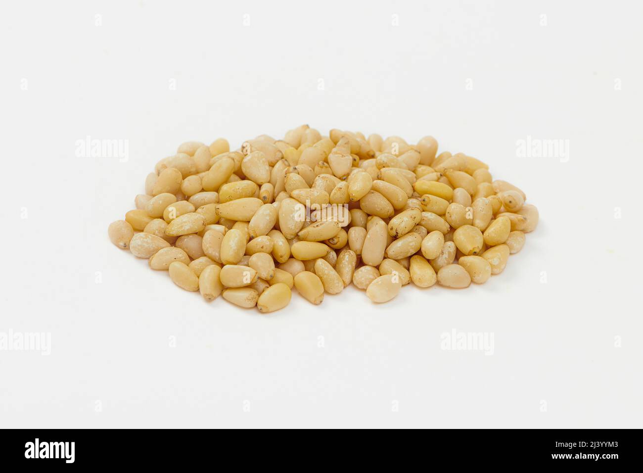 Heap of Pine Nuts Isolated on a White Background. Hulled cedar seeds Stock Photo