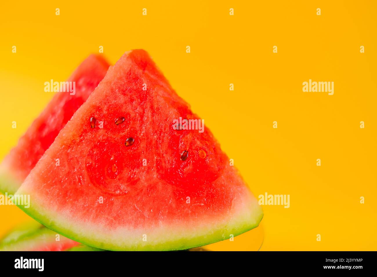 Watermelon. Ripe watermelon in a cut. Slices of watermelon on a yellow ...