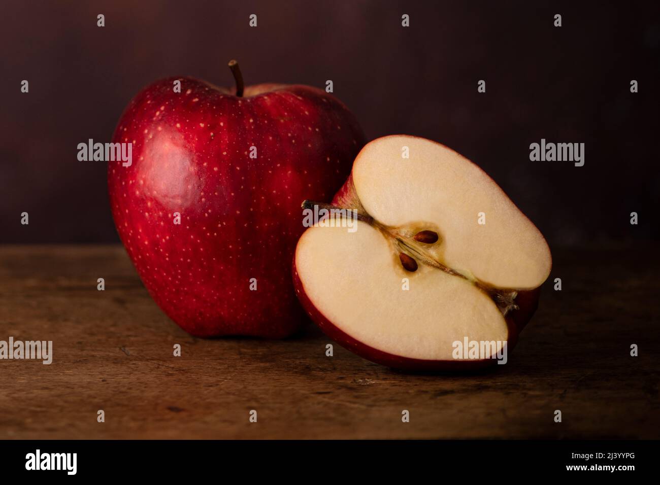 One Whole Apple and One Half Apple on a Wooden Old Surface. Stock Photo