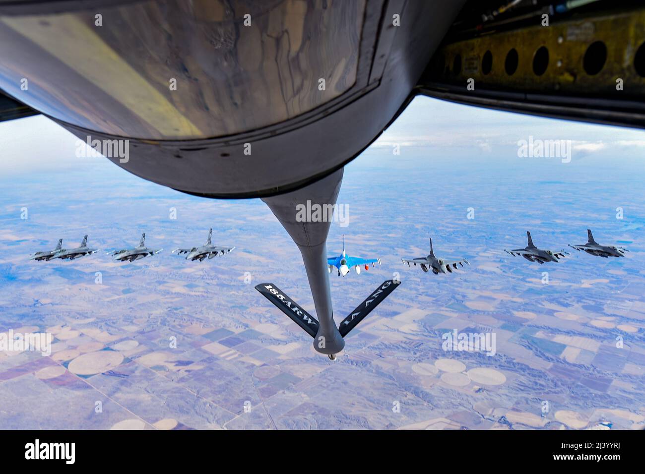 Eight F-16 Fighting Falcons assigned to the 114th Fighter Wing, fly behind a KC-135 Stratotanker from the 185th Air Refueling Wing while traveling to Weapons and Tactics Instructor (WTI) course 2-22 at Marine Corps Air Station Yuma, Ariz., April 1, 2022. WTI is a seven-week training event hosted by Marine Aviation Weapons and Tactics Squadron One (MAWTS-1), providing standardized advanced tactical training and certification of unit instructor qualifications to support Marine aviation training and readiness, and assists in developing and employing aviation weapons and tactics.  (U.S. Air Nation Stock Photo