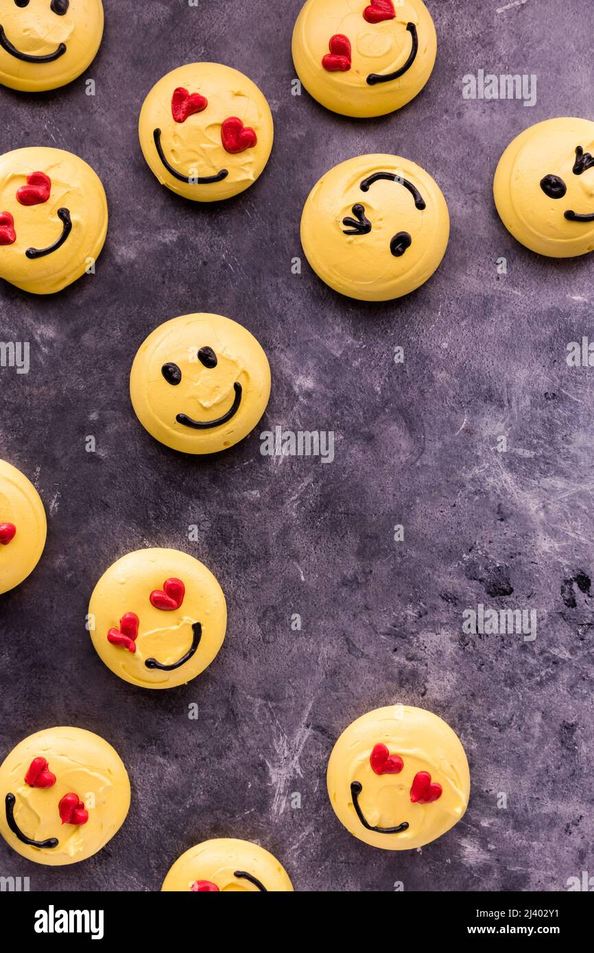 Several smiley face emoticon merengue cookies scattered around with copy space. Stock Photo