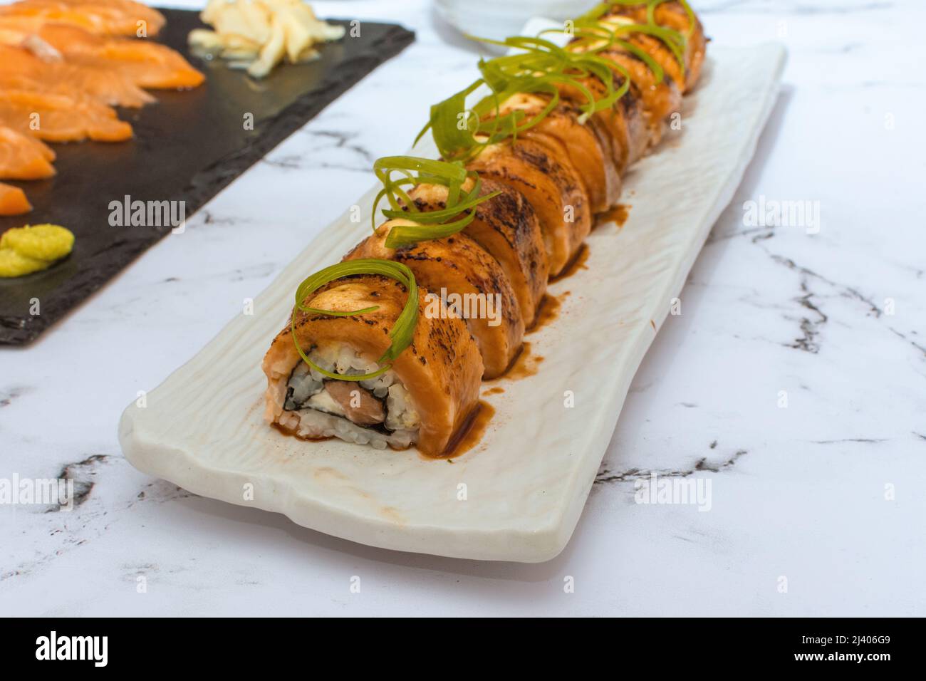 Salmon Sushi Rolls Platted On A White Marble Table. Image can be utilized editorially or commercially. Stock Photo