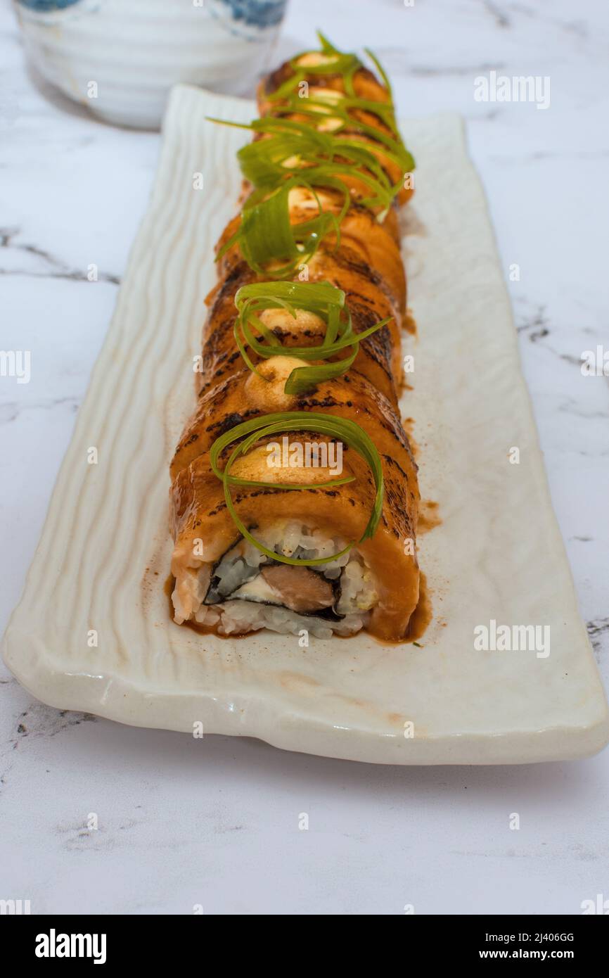 Salmon Sushi Rolls Platted On A White Marble Table. Image can be utilized editorially or commercially. Stock Photo