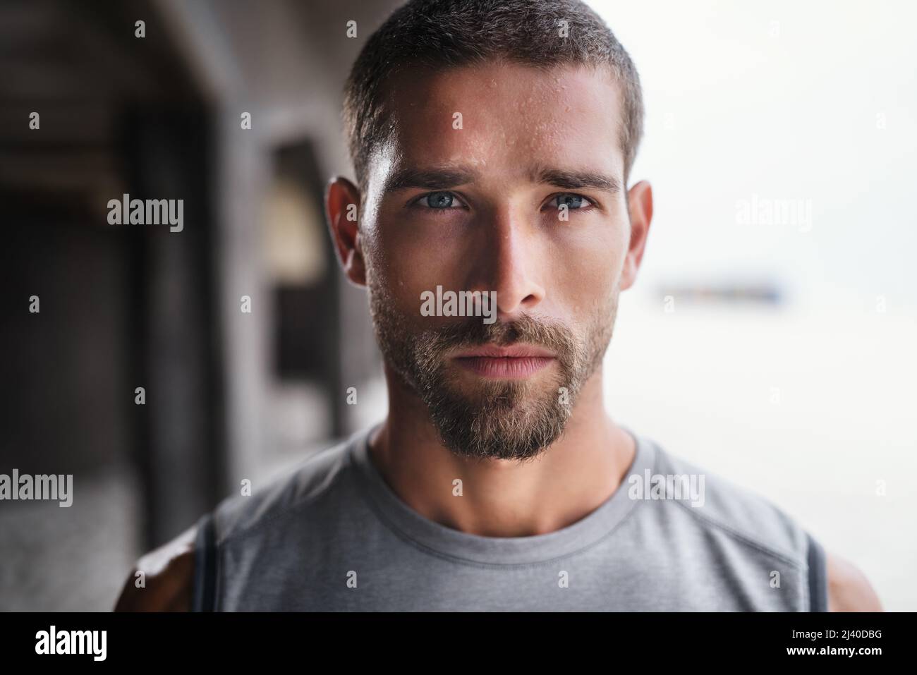 Hes not playing ant games about his fitness. Portrait of a handsome young sportsman looking serious while exercising outdoors. Stock Photo