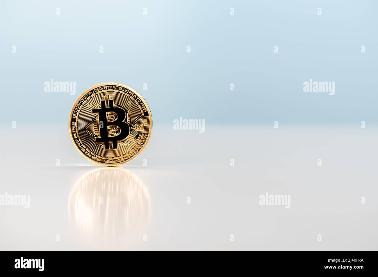 bitcoin. growth or rise price of bitcoin. bitcoin coin stands on table on ight blue background. Crypto currency, bitcoin, BTC. Blockchain technology. Stock Photo