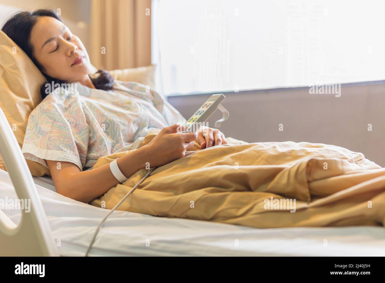 Woman patient hand using remote control for adjust level bed in