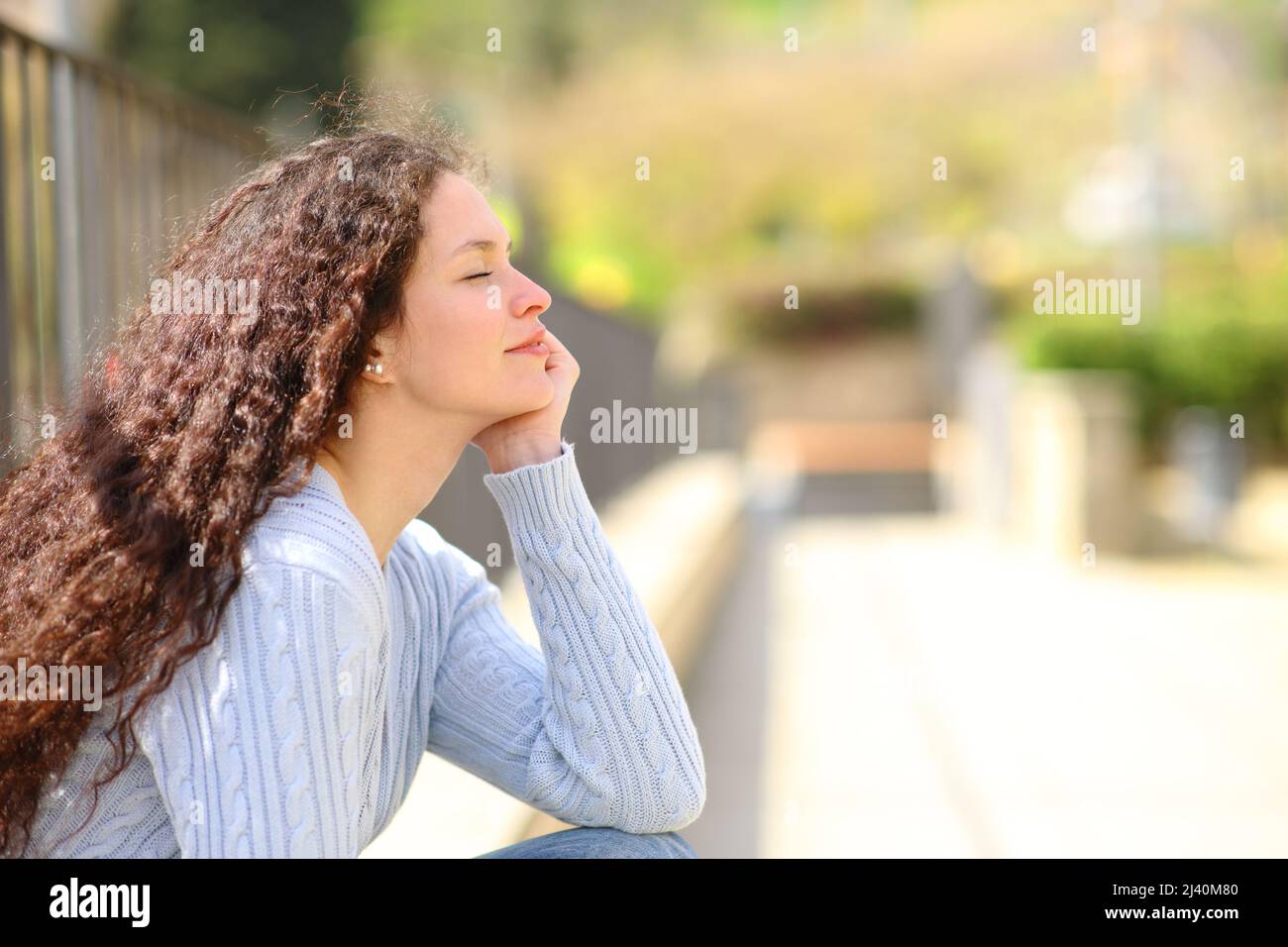 Profile of a woman relaxing a sunny day in a park Stock Photo