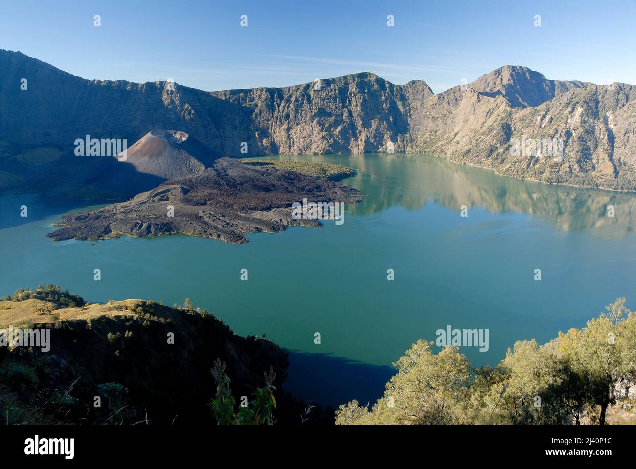 View of Danau Segara Anak (Child of the Sea Lake) within Gunung Rinjani's crater.  Also the cinder cone known as Gunung Baru, New Mountain. Stock Photo