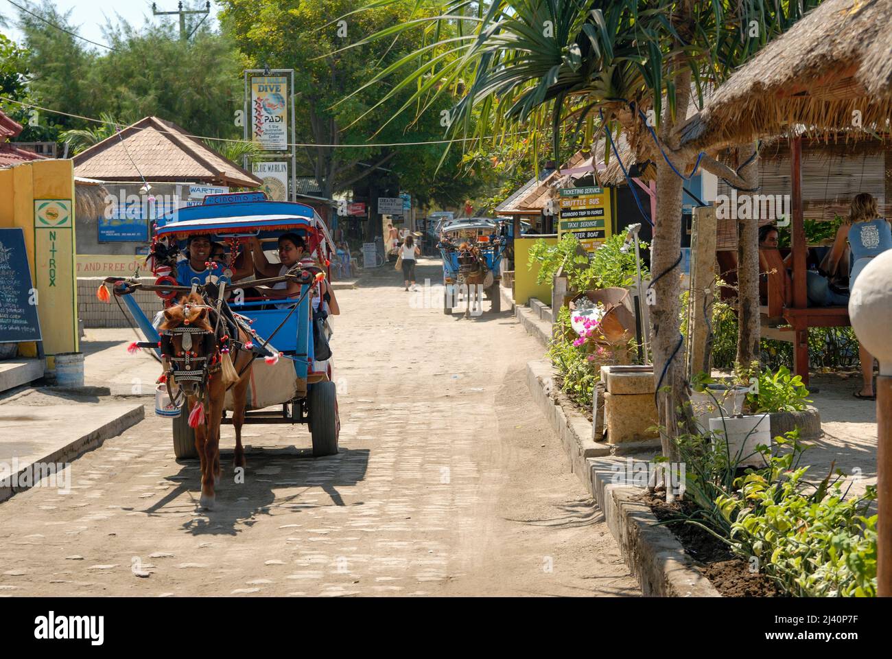 The 'main street' on Gili Trawangan, which has no cars.  Cimodos, horse drawn carts, are the main form of transport. Stock Photo