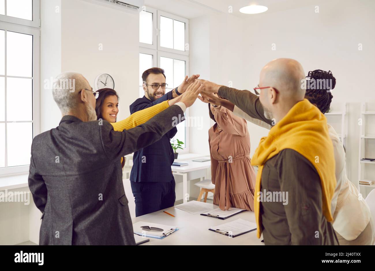 Happy diverse business team motivating each other to work towards their goals together Stock Photo