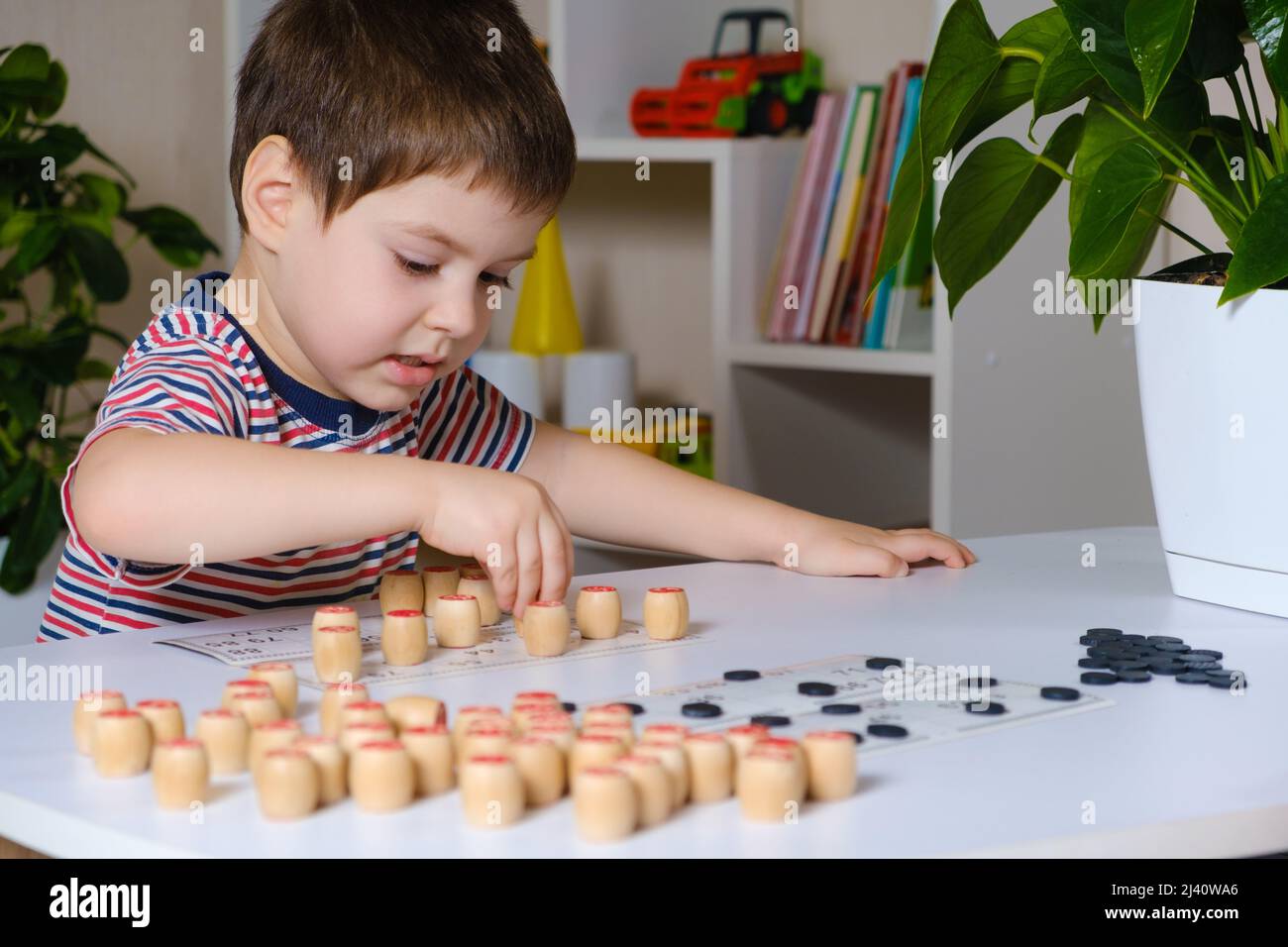 Um menino de 4 anos joga números de estudos de loto usando um jogo