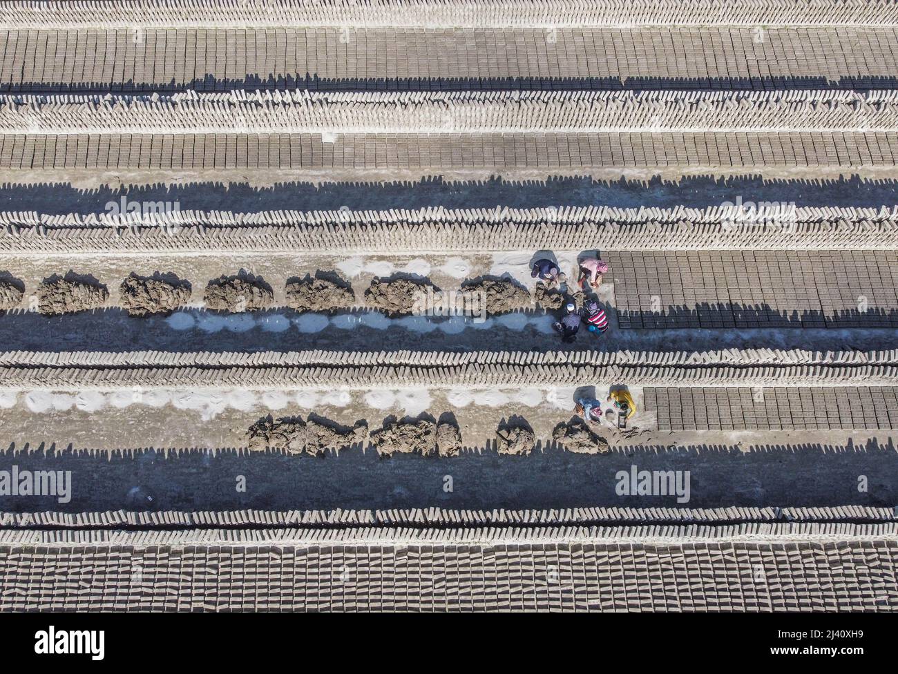Dhaka, Dhaka, Bangladesh. 11th Apr, 2022. Workers are surrounded by  millions of newly-created bricks at a factory. The staggering amount of  bricks were lain in long rows which stretch as far as