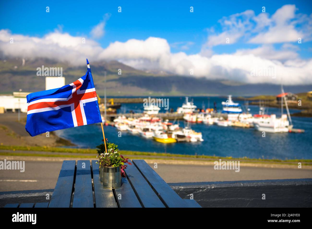 Flag of Iceland placed on a restaurant table with a harbor in the background Stock Photo