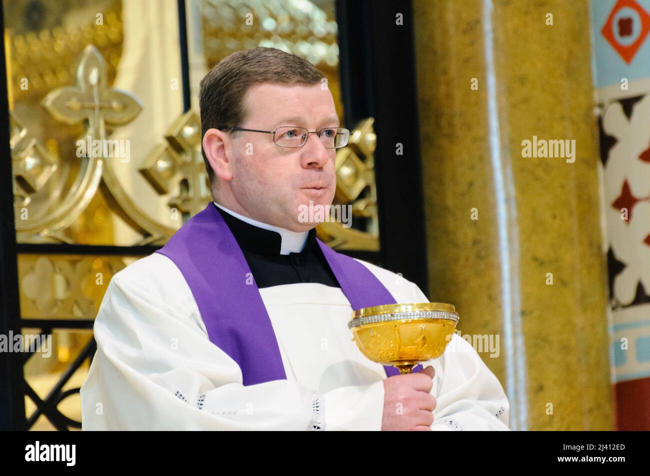 Belfast, Northern Ireland. 2nd January 2010. A priest holds a gold chalice during the requiem mass of Cardinal Cahal Daly at Saint Peter's Cathedral. Stock Photo