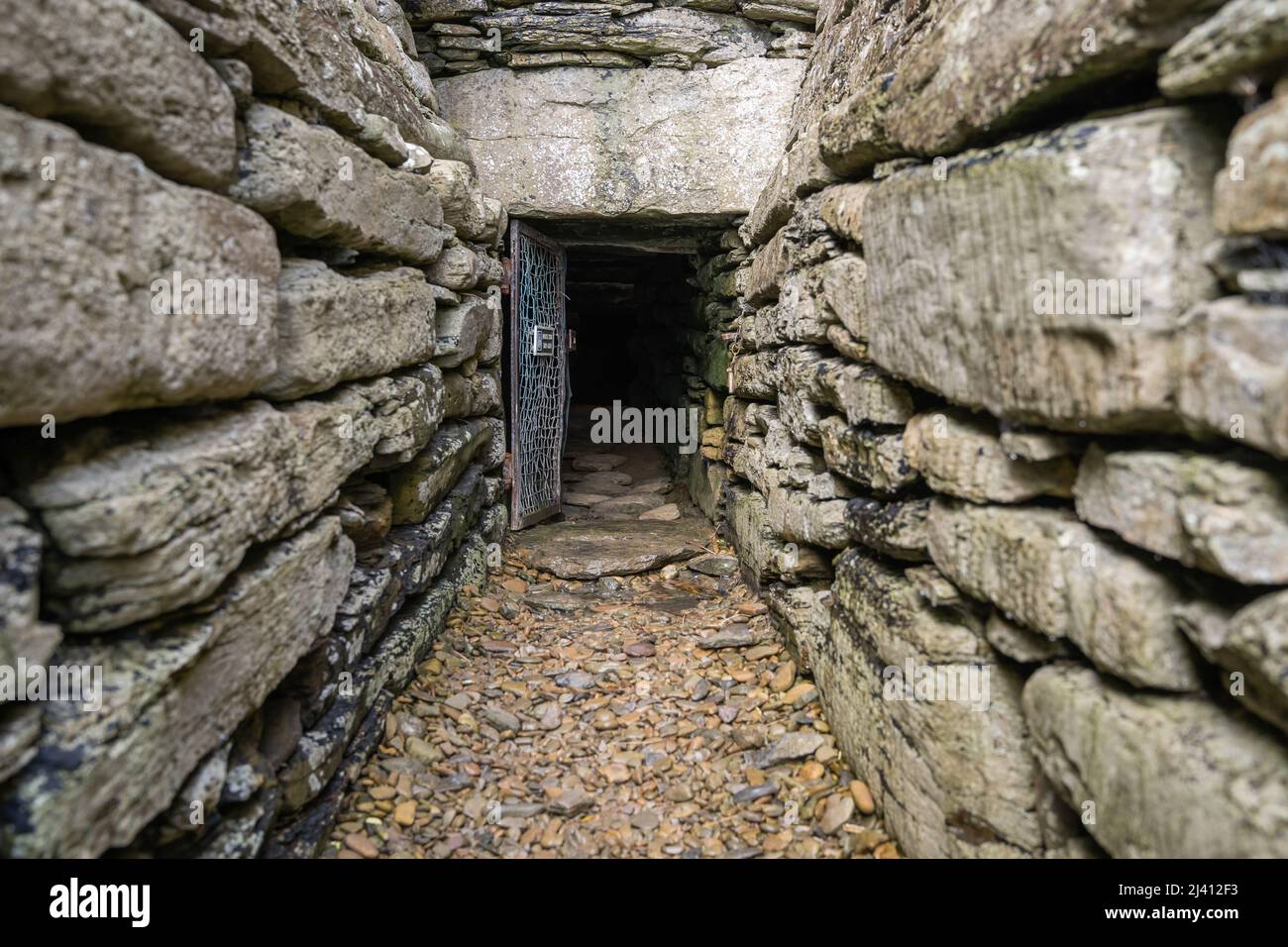 The narrow tunnel entranceway of Quoyness Chambered Cairn. You have to crawl 3 metres through the passageway to emerge inside the Neolithic tomb. Stock Photo