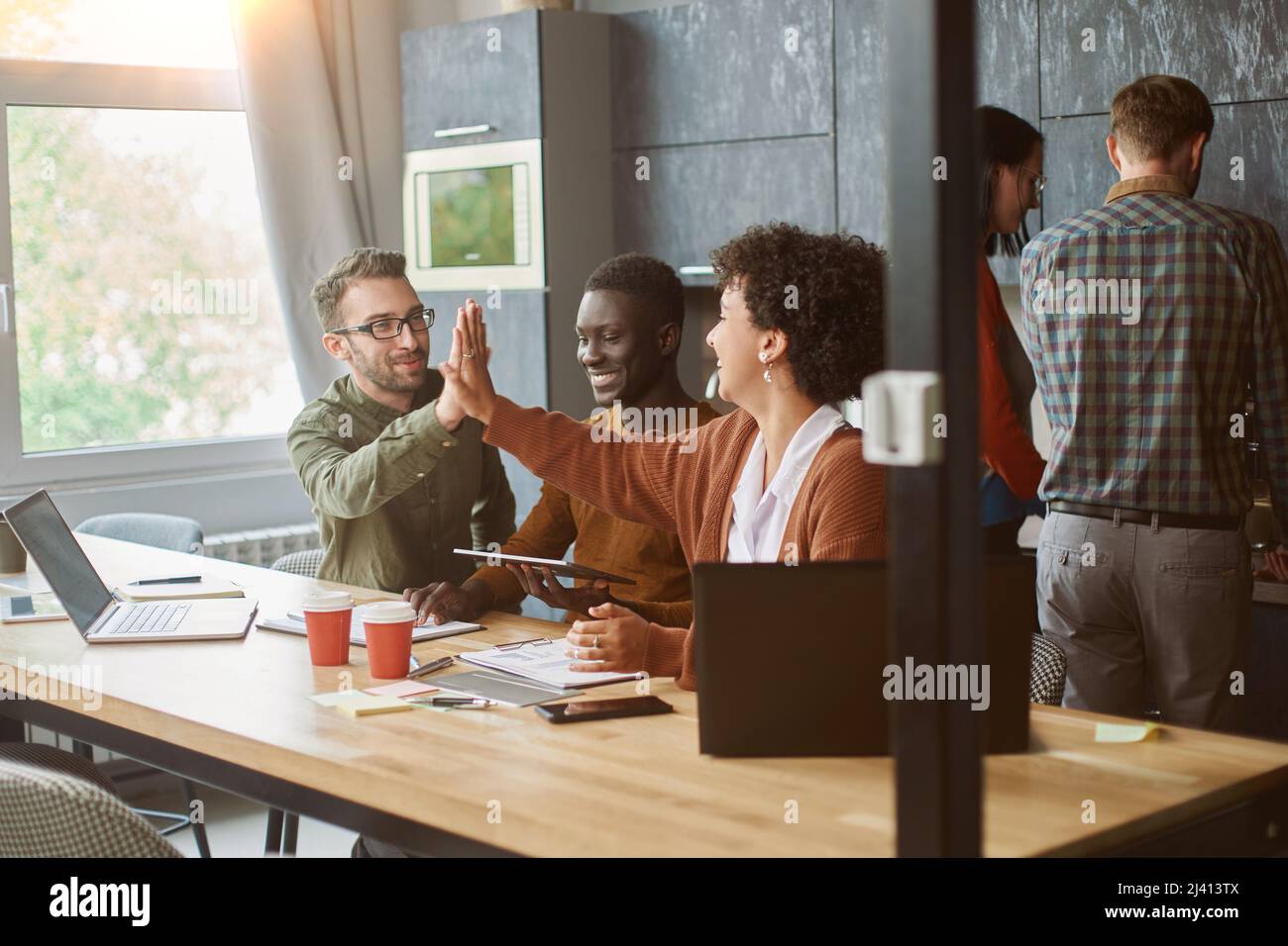 business colleagues giving each other a high five. Stock Photo