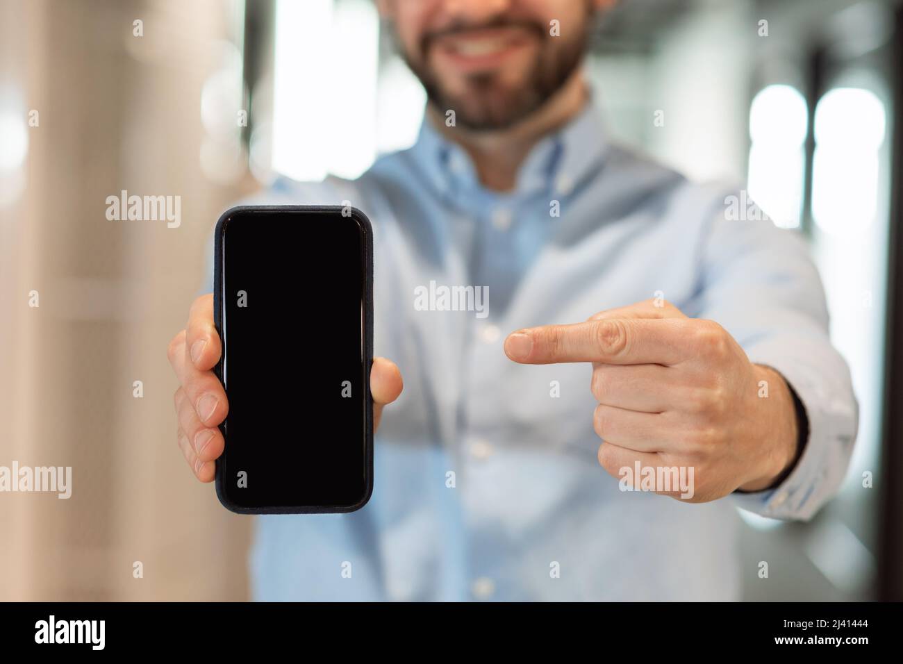 Businessman pointing at black empty smartphone screen Stock Photo