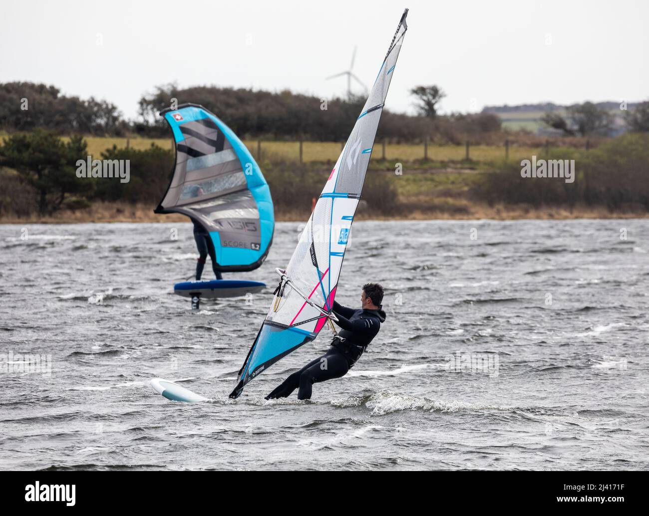 People wind foiling on Stithians Lake, Menherion in South West Cornwall