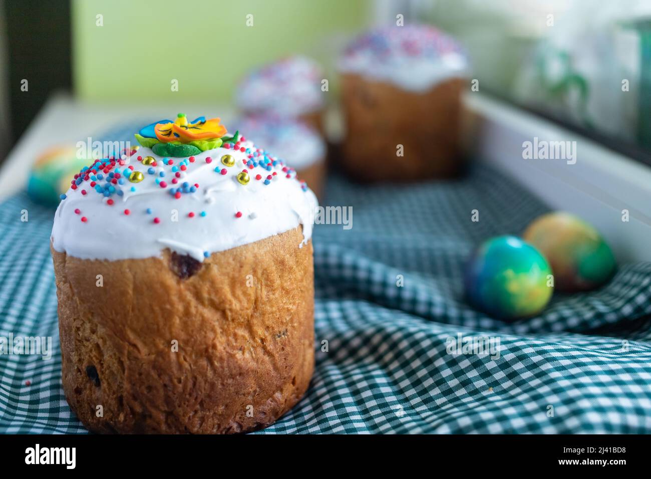 Easter composition with traditional Russian Easter bread kulich, Easter eggs and lilac flowers on table. Stock Photo