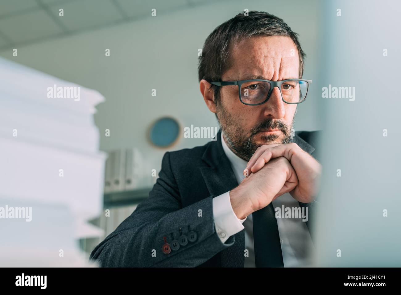 Distressed businessman looking at laptop screen in business office, selective focus Stock Photo