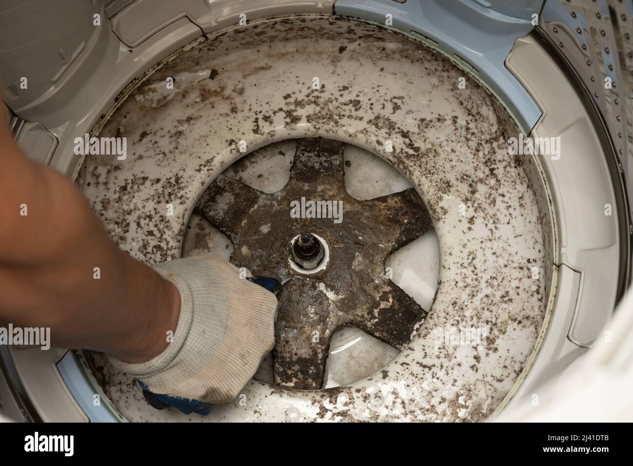 man taking apart a dirty washing machine Stock Photo Alamy