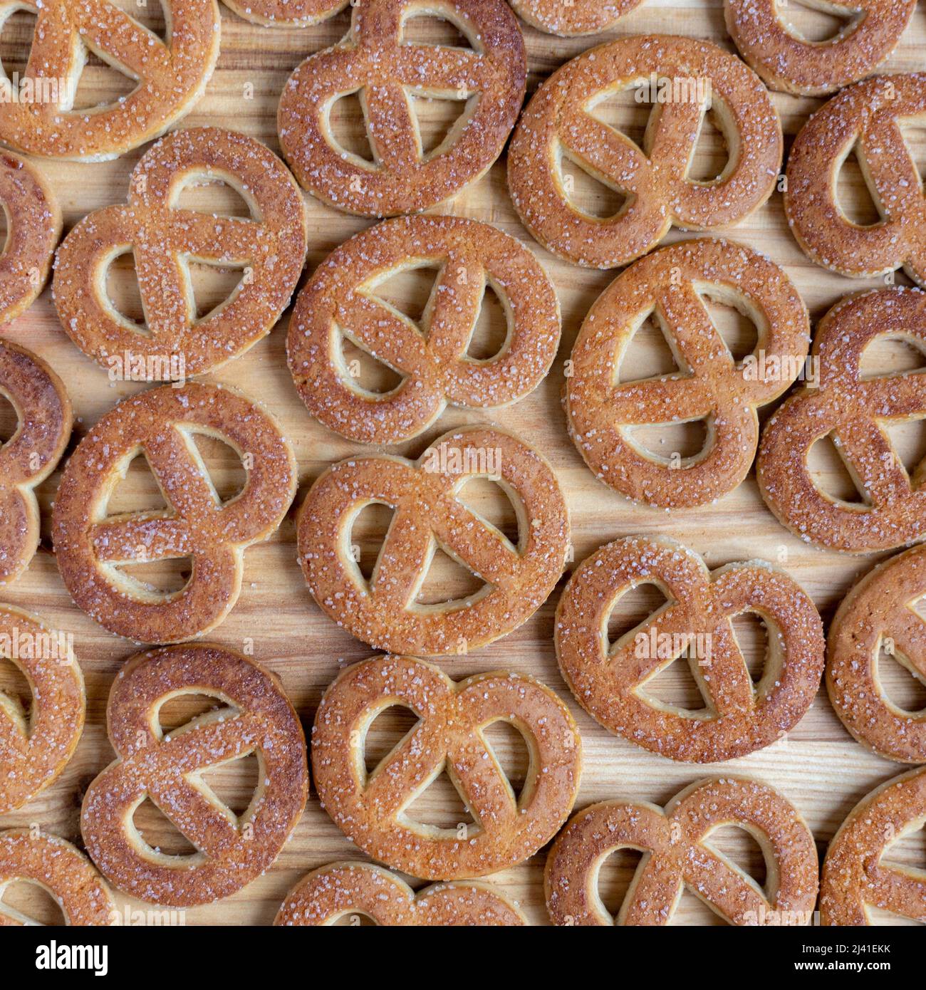 Pretzels sprinkled with sugar lie on a wooden surface Stock Photo
