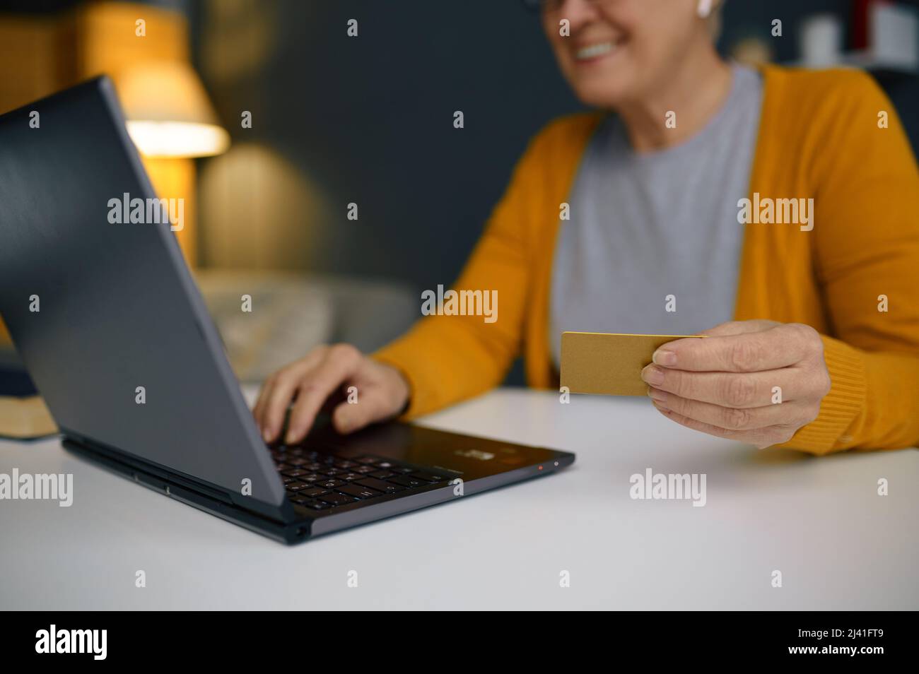 Mature woman doing online payment on laptop Stock Photo