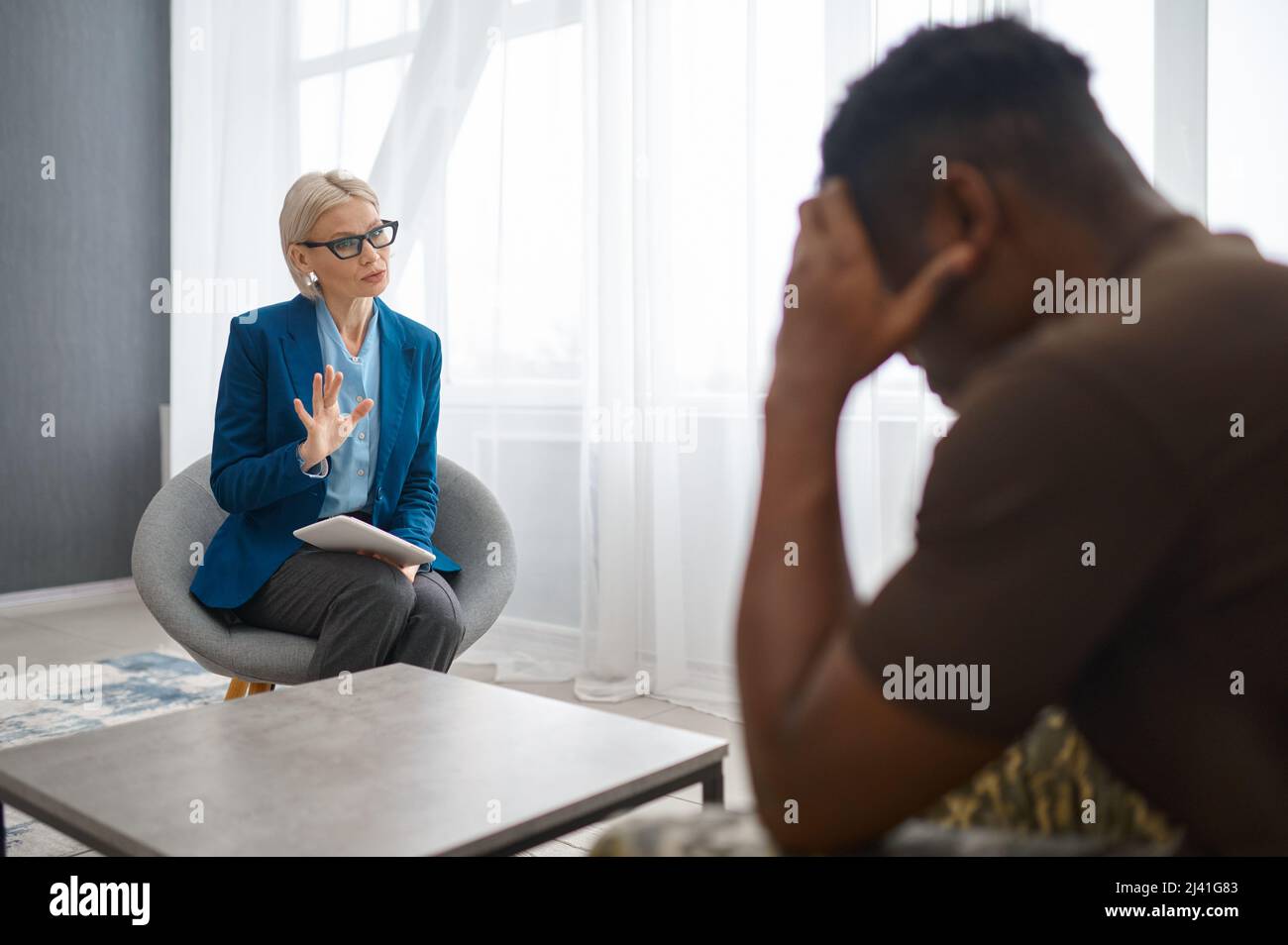 Frustrated military patient talking with doctor psychologist Stock Photo