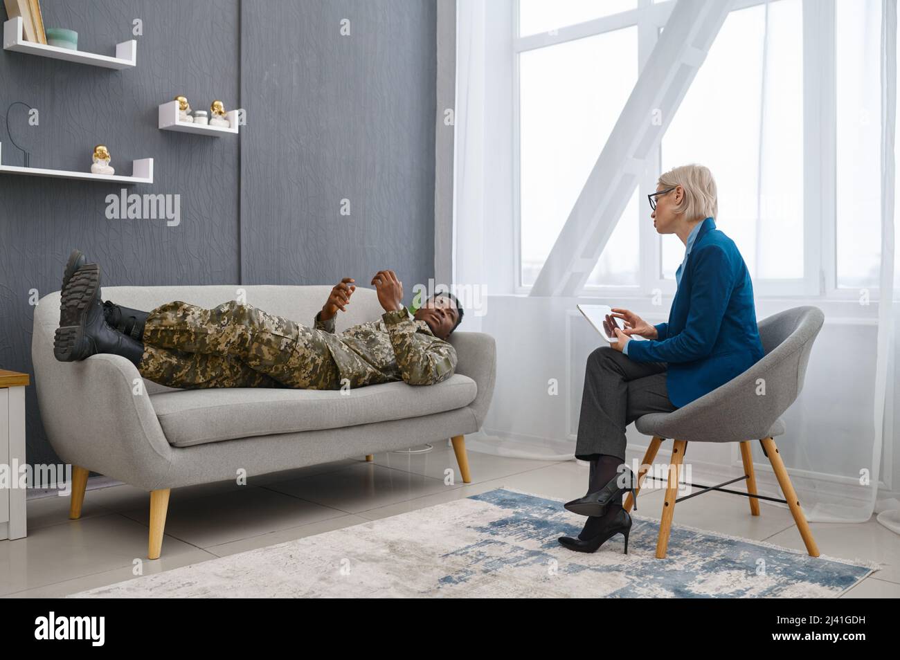Psychologist making notes while male soldier talking Stock Photo