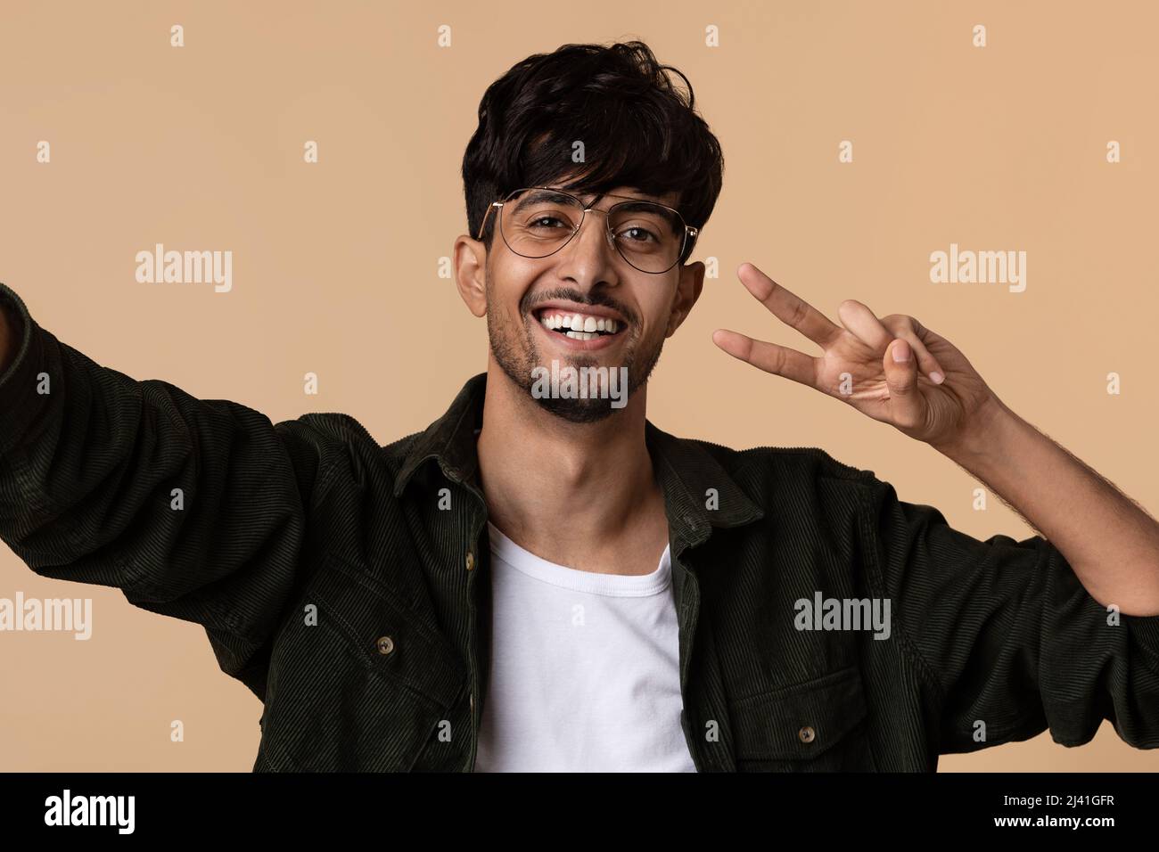 Cheerful middle eastern man taking selfie, gesturing Stock Photo