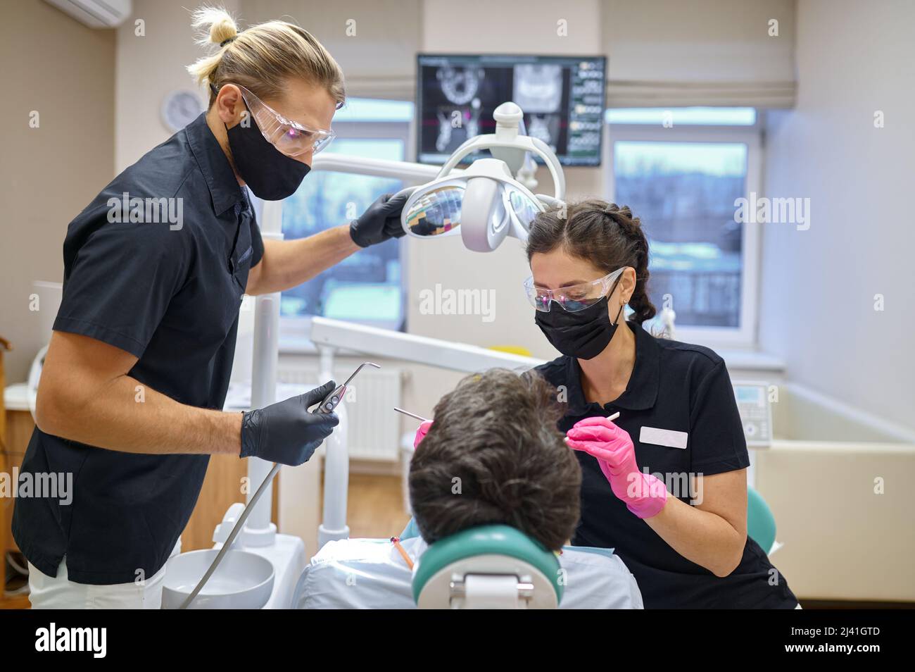 Dentist curing male patient at dental clinic Stock Photo
