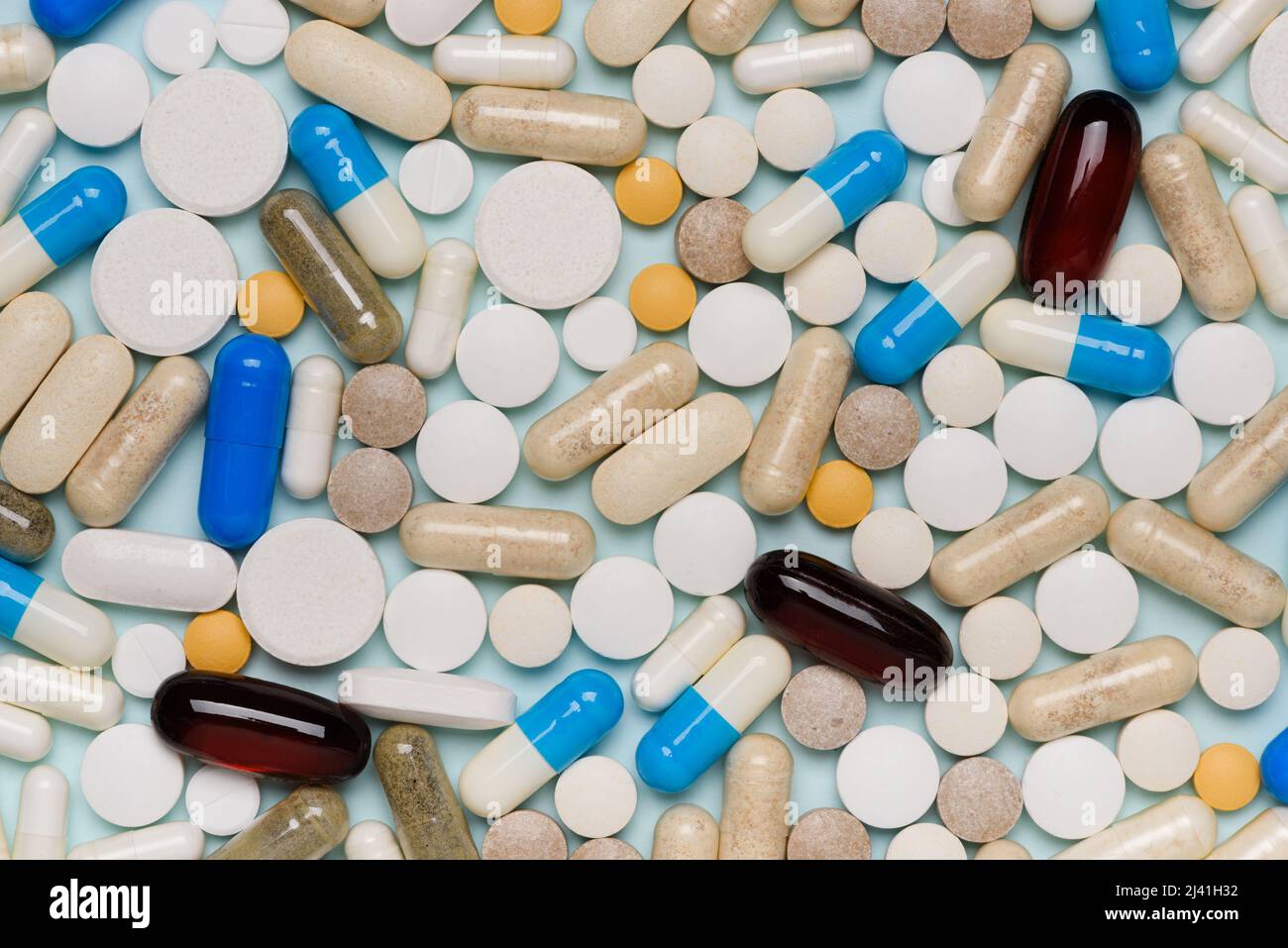 Pills texture background, different assorted drugs capsules on blue background top view. Stock Photo