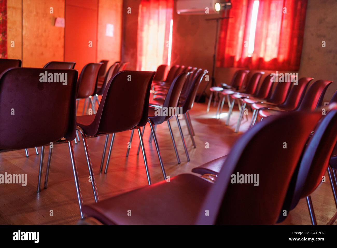 Many chairs in a room for an event with red ambiance Stock Photo Alamy