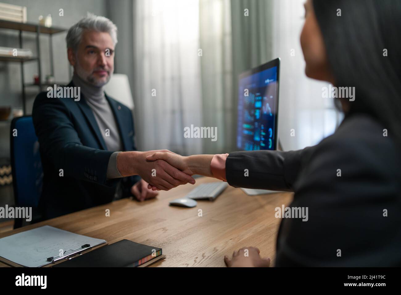 Financial advisor shaking hand with his client indoors in office. Stock Photo