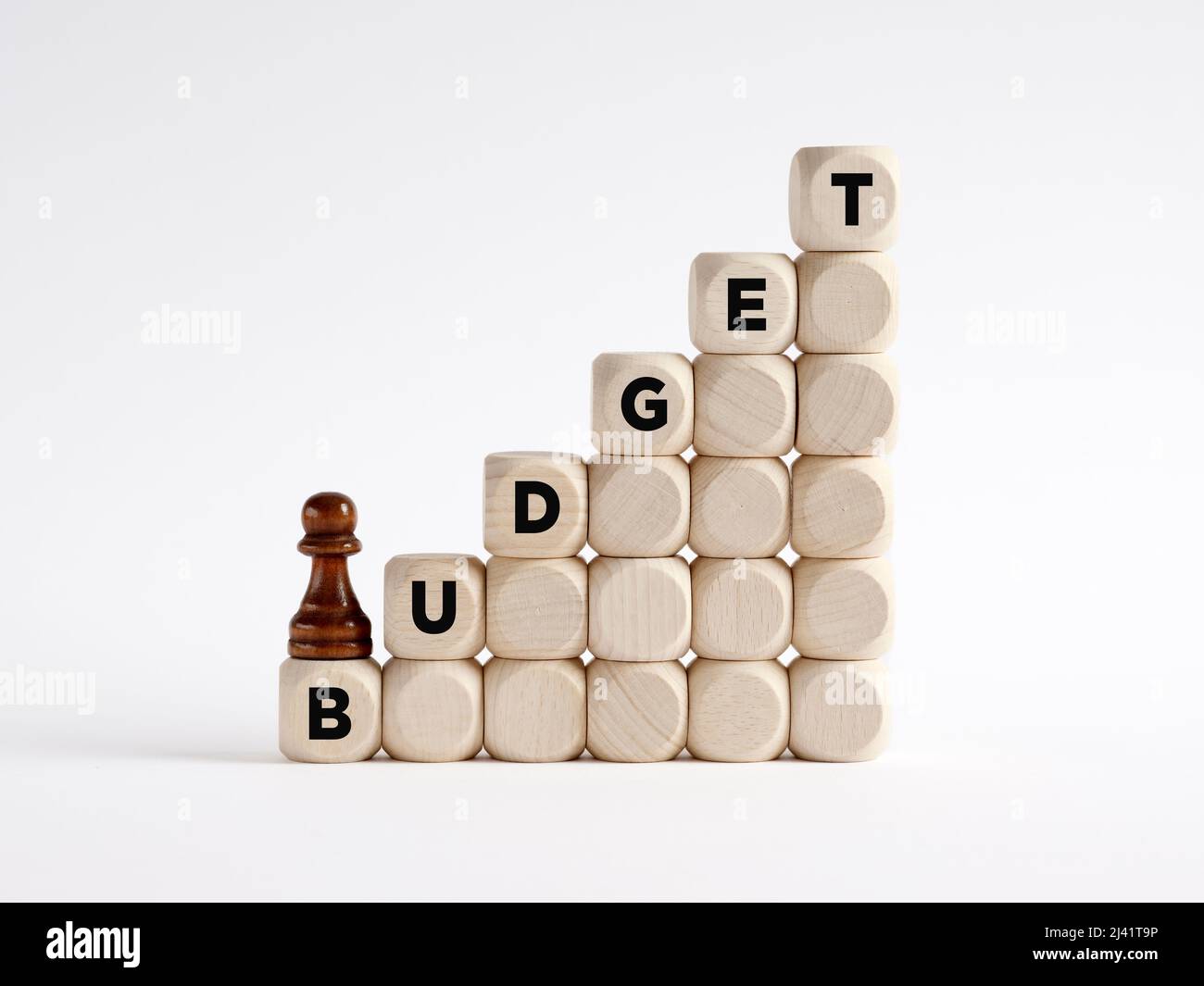 Chess pawn is climbing the ladder of wooden cubes with the word budget. Growing or increasing budget concept. Stock Photo