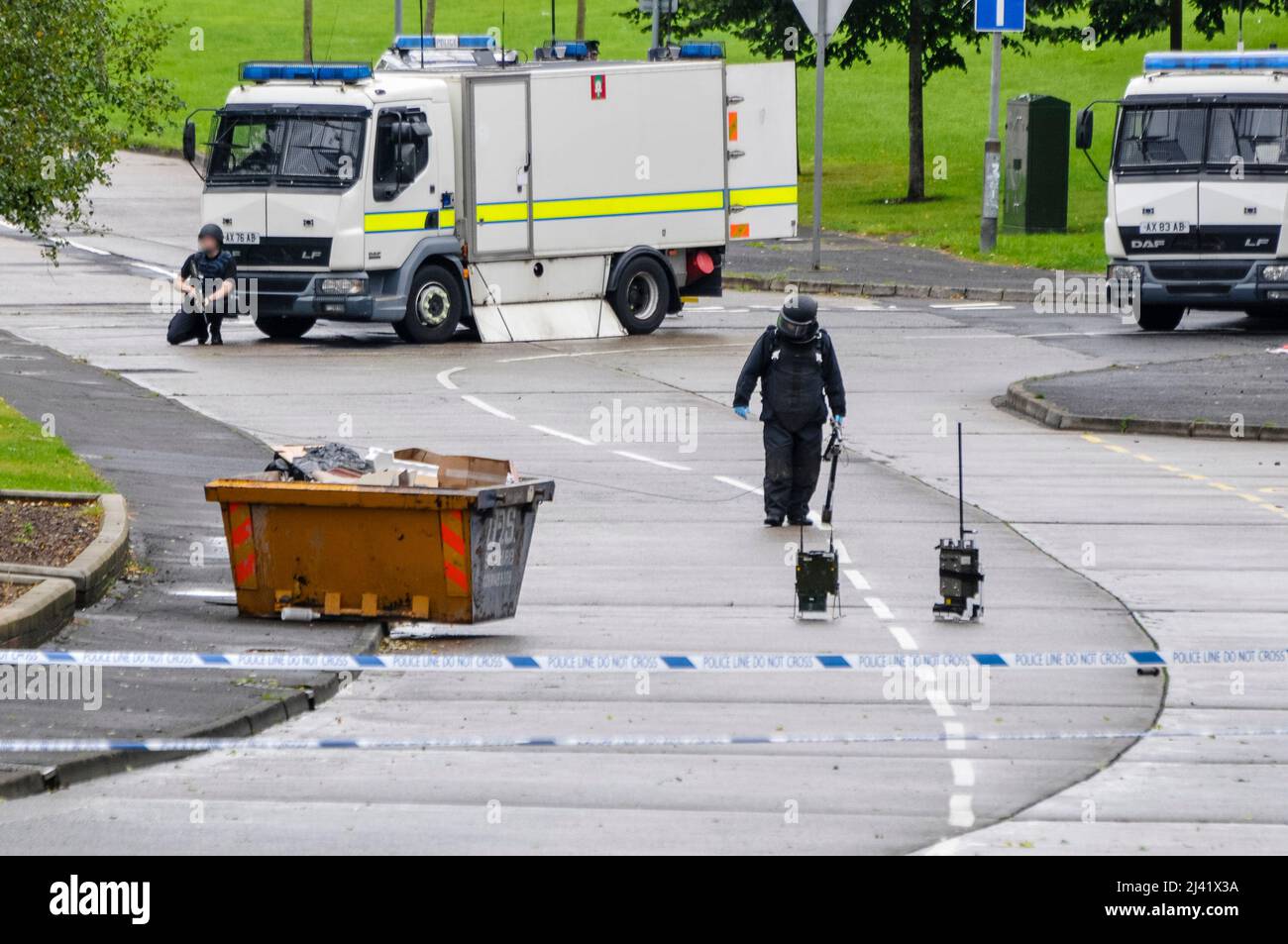 Belfast, Northern Ireland. 11th September 2013 - An army ATO approaches an object found on a residential street in the Twinbrook area of West Belfast, with an armed soldier behind him providing cover.  PSNI have confirmed it was a viable device which has been taken away for examination. Stock Photo