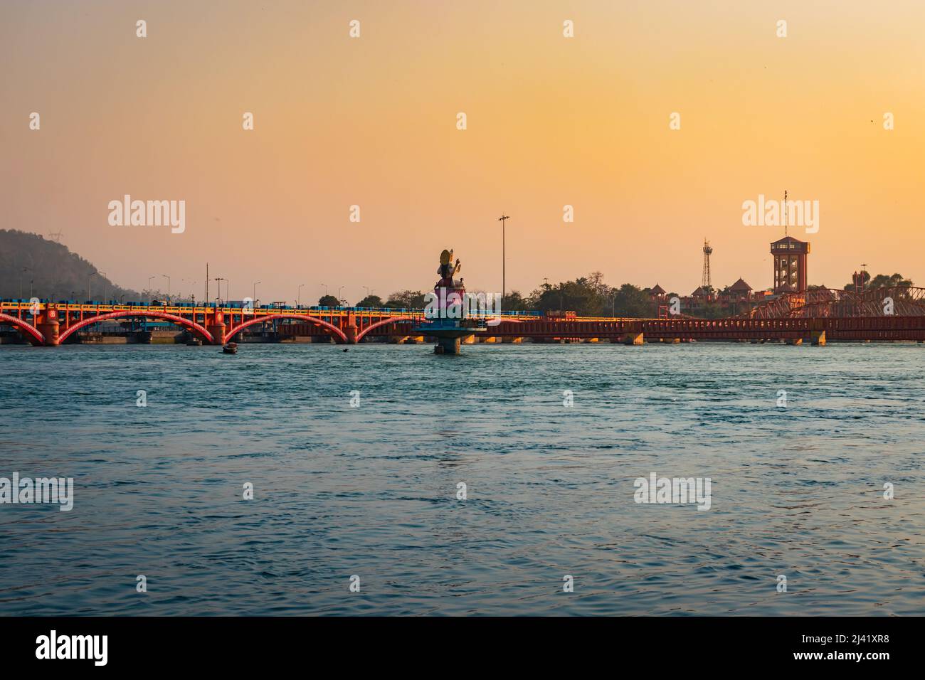 isolated iron bridge and hindu goddess statue over ganges river with colorful sky at evening image is taken at haridwar uttrakhand india. Stock Photo