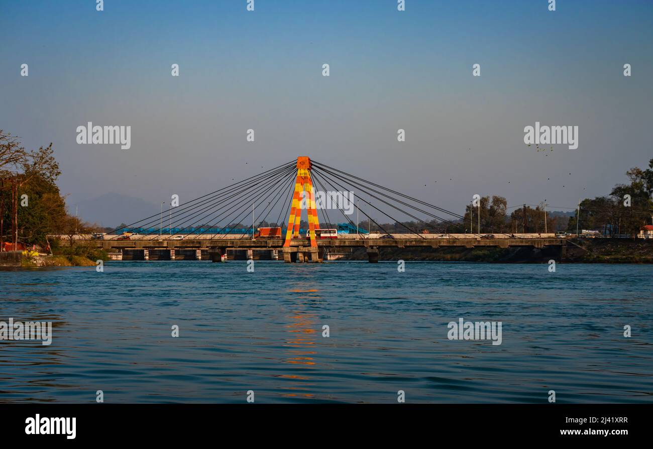 isolated cable bridge over ganges river with colorful sky at evening image is taken at haridwar uttrakhand india. Stock Photo