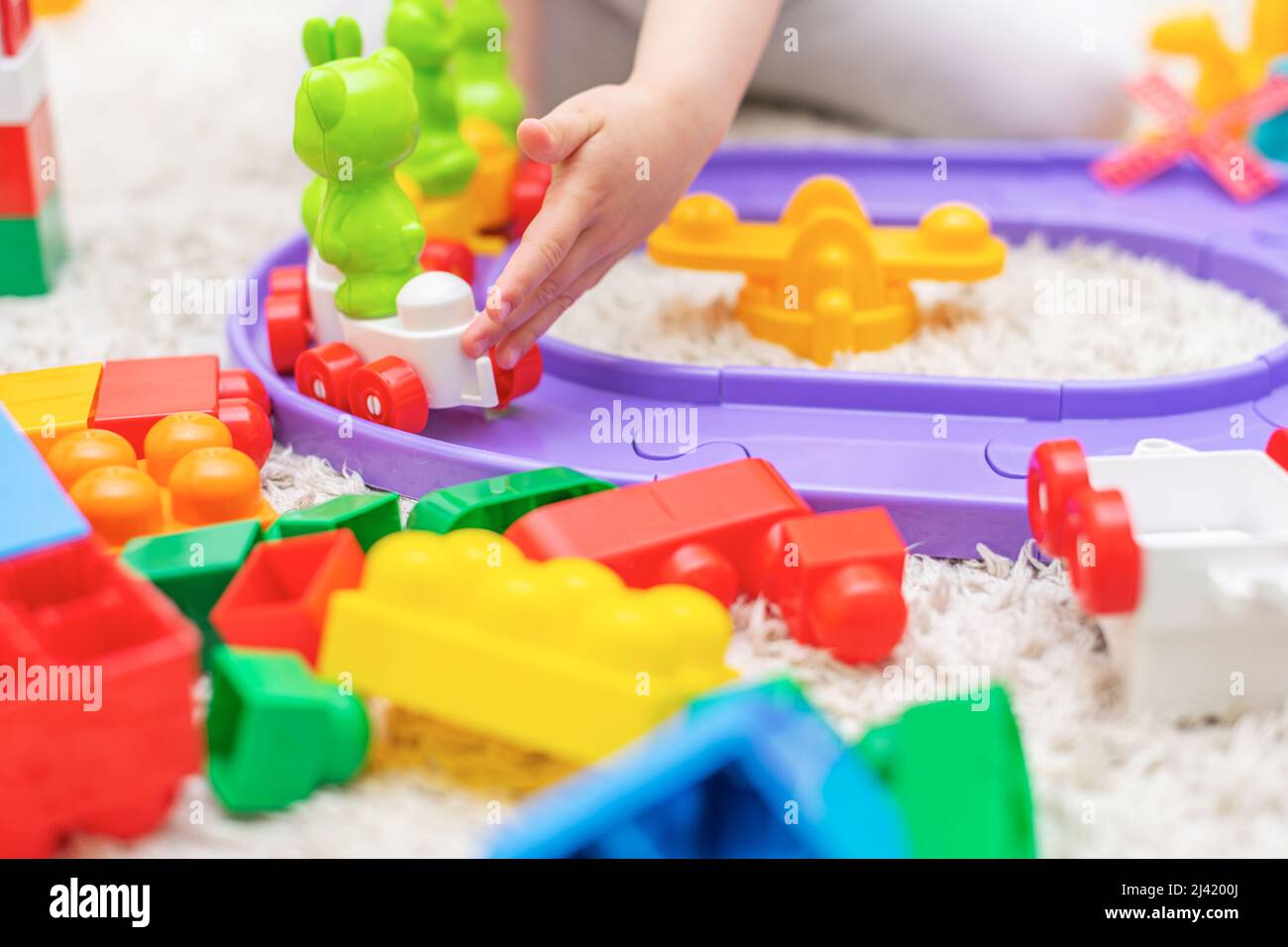 The child collects a multi-colored constructor. Stock Photo