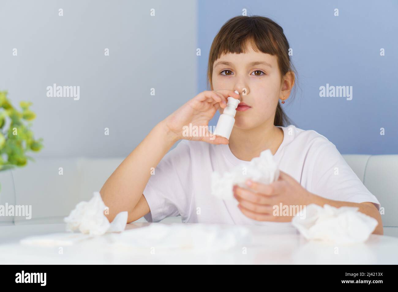 Little girl with runny nose does nasal spray irrigations to stop