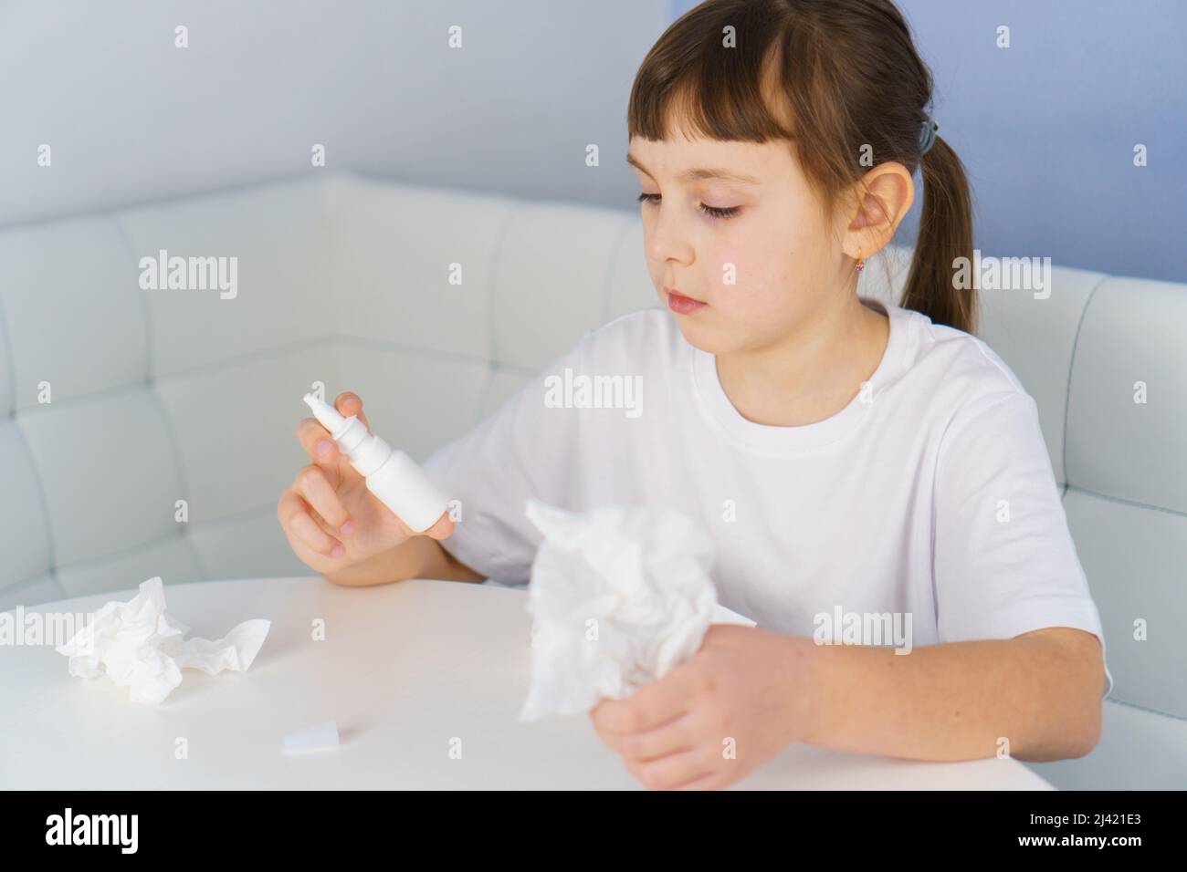 Nasal spray bottle and paper tissue in girl hands. Allergy, viral and