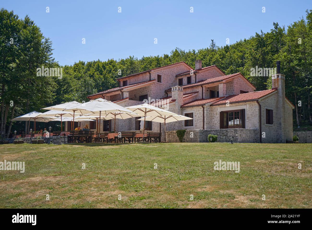 CETINJE, MONTENEGRO - JULY 23, 2021: Country hotel Ivanov Konak made of stone near the forest Stock Photo