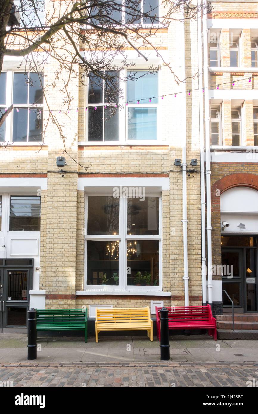 Coloured benches in Newburgh Street central London, UK Stock Photo