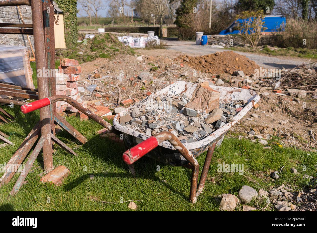Wheelbarrow containing building rubble at a building site. Stock Photo