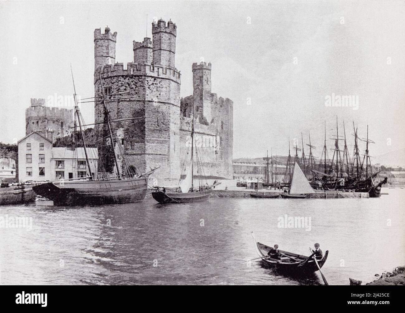 Caernarfon Castle, aka Carnarvon Castle or Caernarvon Castle, Caernarfon, Gwynedd, north-west Wales, seen from across the River Seiont in the 19th century.  From Around The Coast,  An Album of Pictures from Photographs of the Chief Seaside Places of Interest in Great Britain and Ireland published London, 1895, by George Newnes Limited. Stock Photo