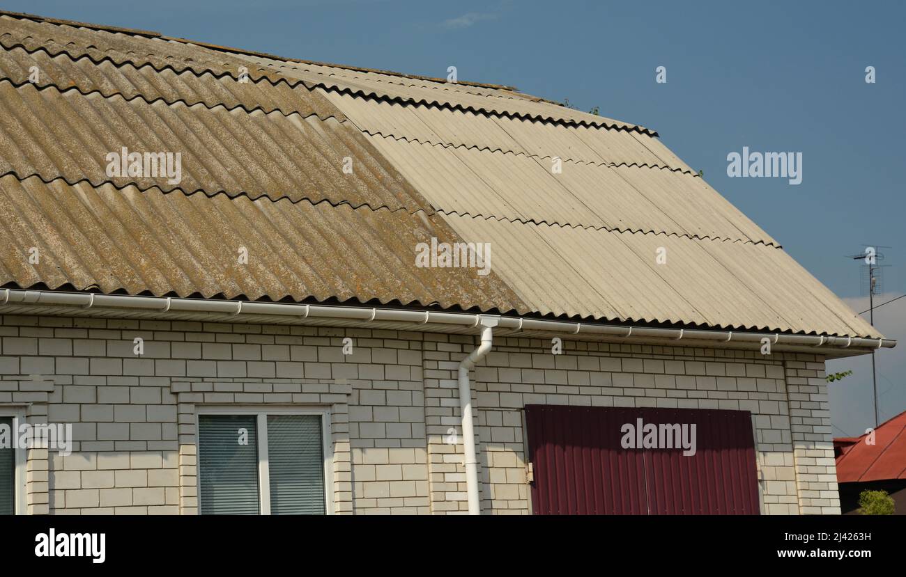 Asbestos roof replacement and repair. A closeup of an old asbestos roof with a new replaced