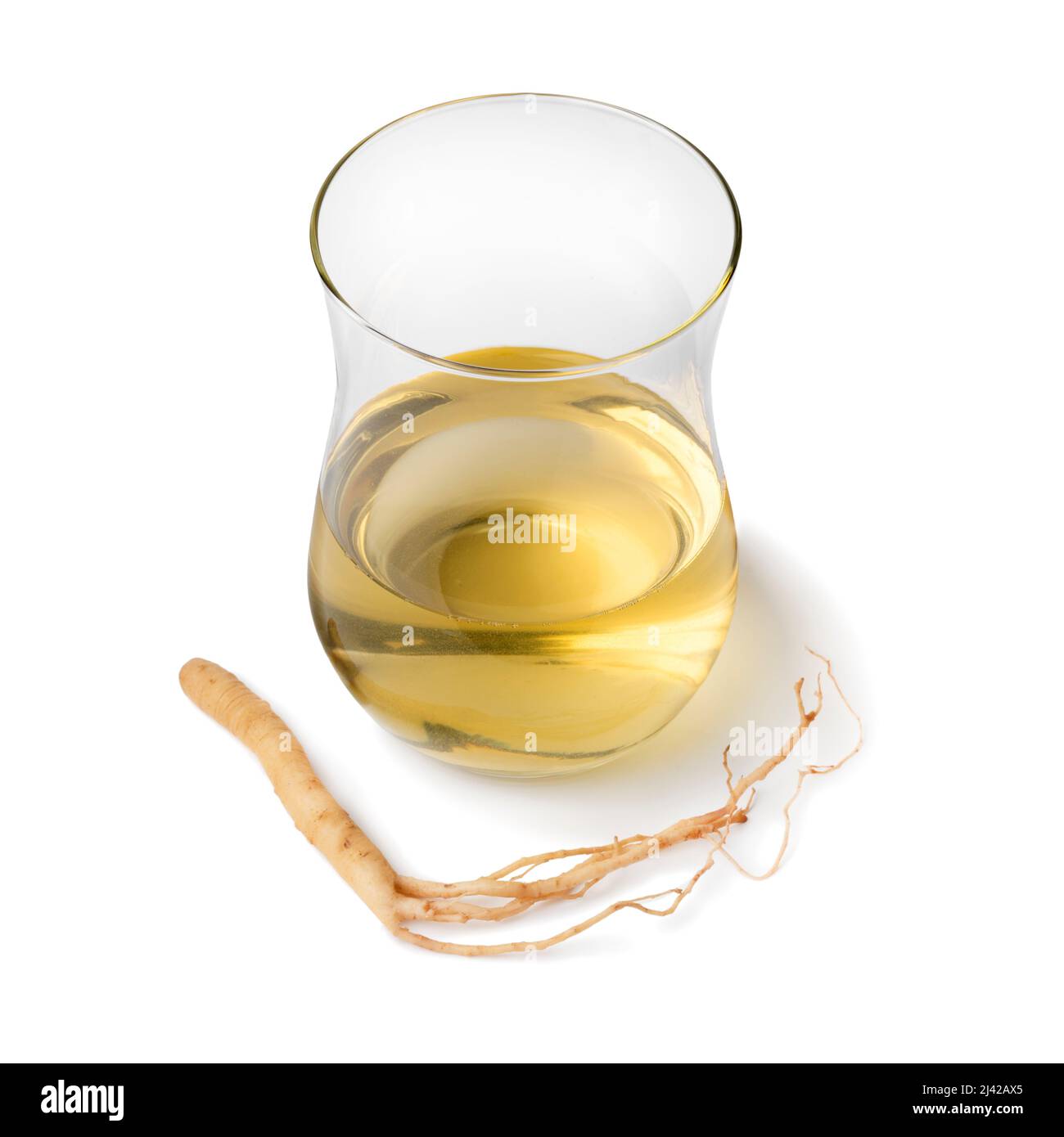 Single tea glass with Ginseng drink and ginseng root isolated on white background close up Stock