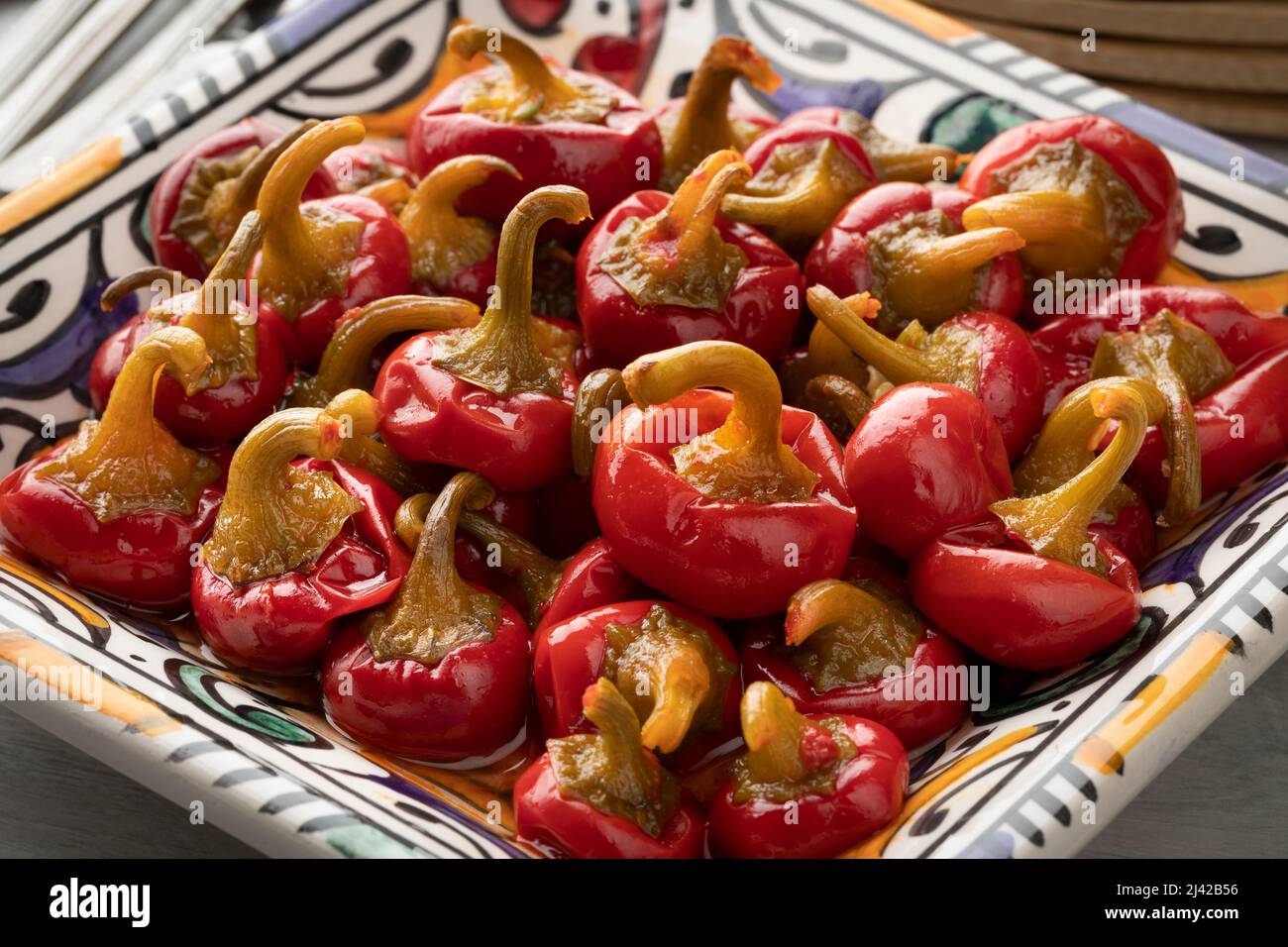 Dish with pickled spicy Red Cherry chile peppers close up Stock Photo