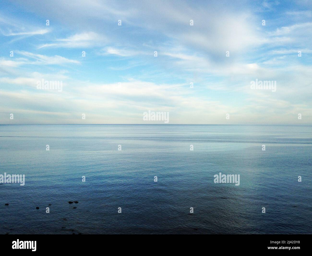 Ocean view - blue and white sky and reflective water Stock Photo - Alamy