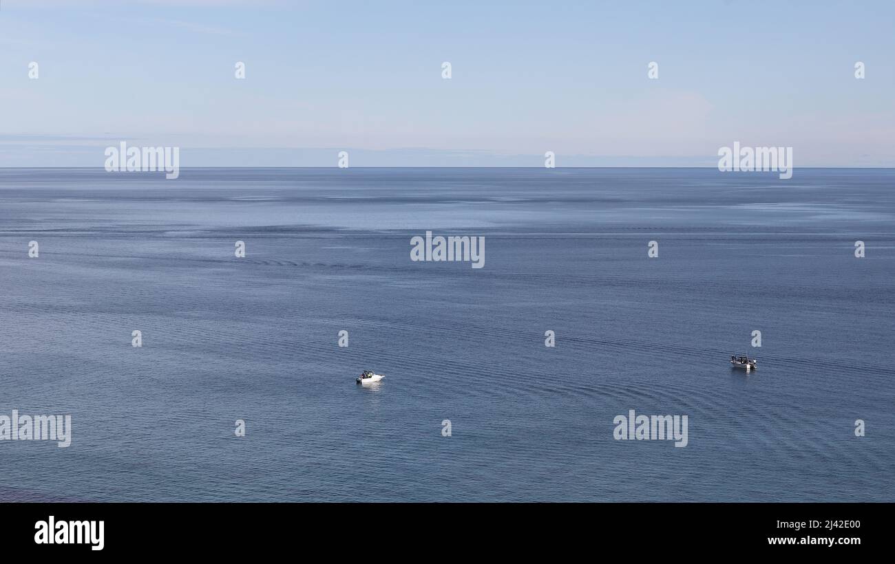 Ocean view - calm waters and fishing boats Stock Photo - Alamy